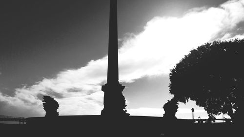 Low angle view of silhouette tree against cloudy sky