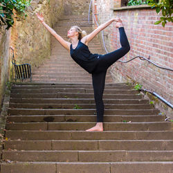 Young woman doing yoga on steps