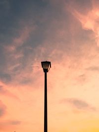 Low angle view of street light against cloudy sky