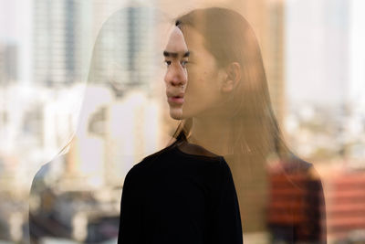 Portrait of young woman looking away in city