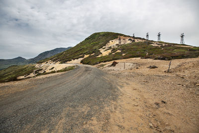 Scenic view of road by mountains against sky