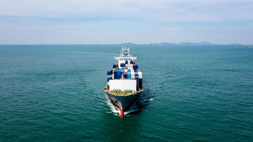 Angle view in front container ship full speed in green sea, business and industry transportation 