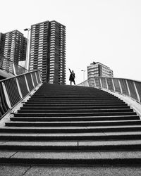 Low angle view of man walking on staircase against building