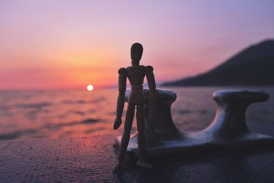 Silhouette man on beach against sky during sunset