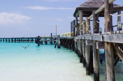 Wooden pier on sea against sky