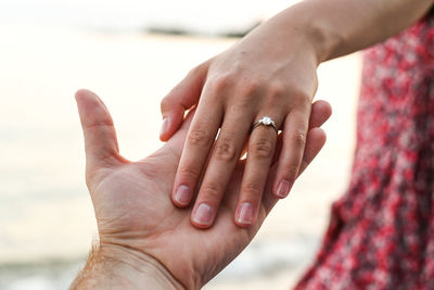 Midsection of couple holding hands