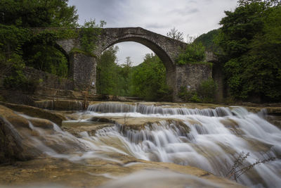 Scenic view of waterfall against sky