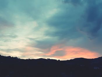 Scenic view of silhouette mountains against dramatic sky