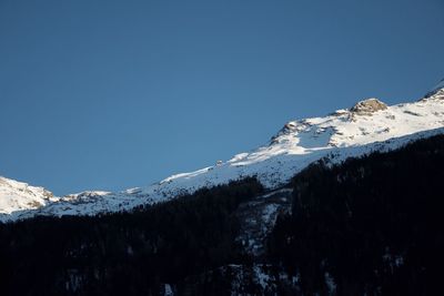 Scenic view of snowcapped mountains against clear blue sky