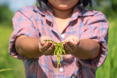 Midsection of woman holding flower