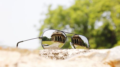 Close-up of sunglasses on retaining wall against sky