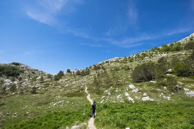 Woman standing on mountain against sky