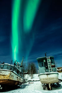 Abandoned boat on land against sky at night