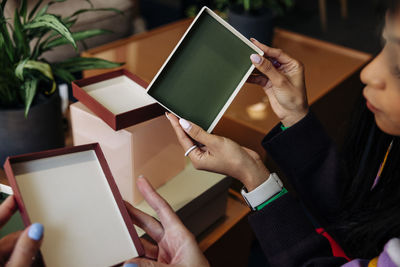 Hands of female entrepreneurs holding box lids at office