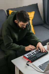 Man using laptop while sitting on sofa at home