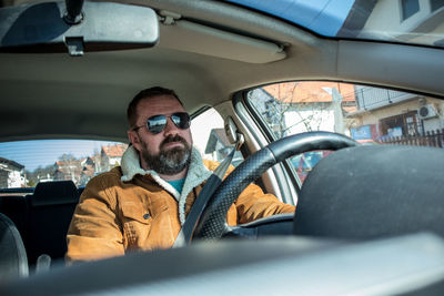 Portrait of man sitting in car