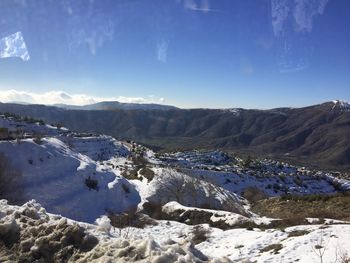 Scenic view of snowcapped mountains against blue sky