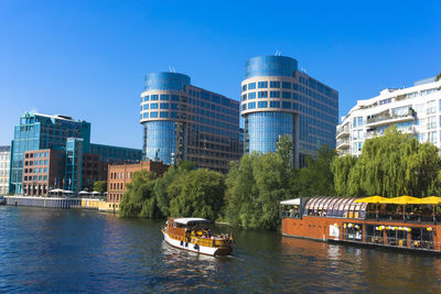 City by river against clear blue sky