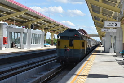 Train at railroad station platform against sky