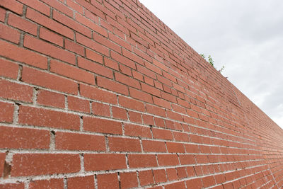 Low angle view of brick wall against sky