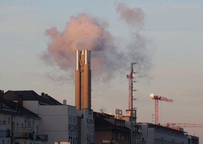 Smoke emitting from chimney against sky