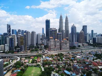 Aerial view of city against cloudy sky