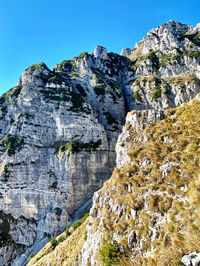 Low angle view of rocky mountains against clear sky