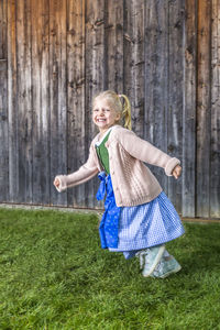 Portrait of happy girl standing on field