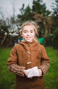 Portrait of smiling girl standing against trees