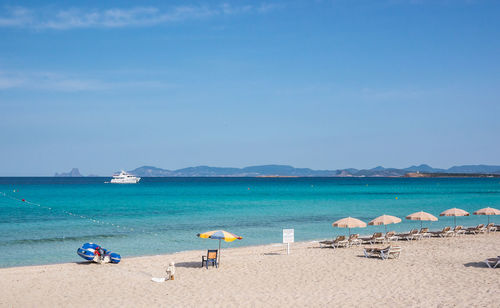 People on beach against blue sky