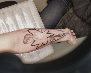 Midsection of woman hand with tattoo