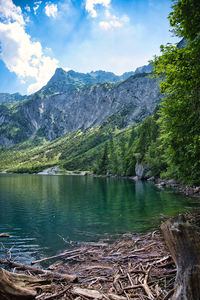 Scenic view of lake by mountains against sky