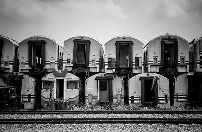 Railroad tracks by buildings against sky