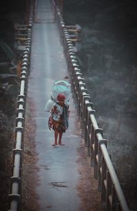 Rear view of woman walking on bridge