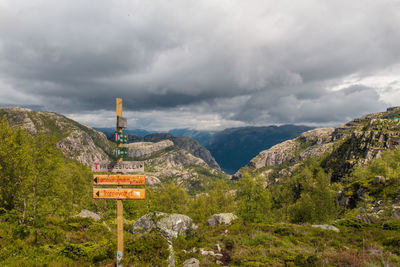 Information sign by mountains against sky