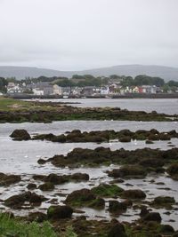 Scenic view of sea in front of town against sky