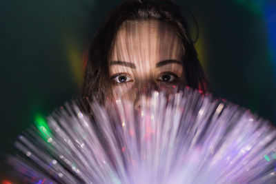 Close-up portrait of young man with illuminated fiber optics