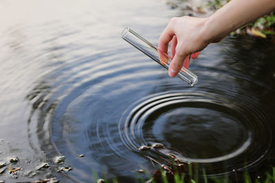 Scientist and biologist hydro-biologist takes water samples for analysis. hand is collects water in