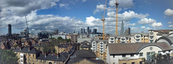 Panoramic view of cityscape against cloudy sky