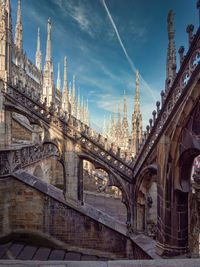 Low angle view of bridge and buildings against sky