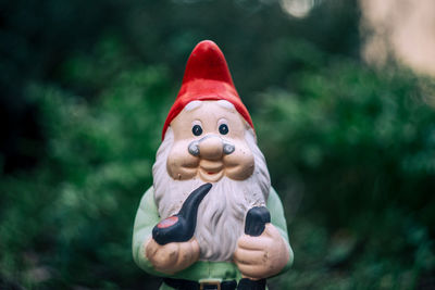 Close-up of garden gnome figurine against christmas tree
