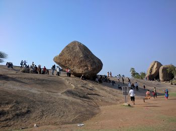 People on beach against clear sky