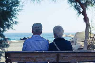 Rear view of people sitting against built structure