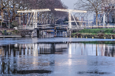 Bridge over lake against buildings in city