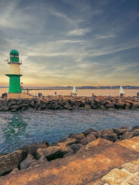 The green lighthouse on the breakwater of the baltic sea town warnemuende in the evening light