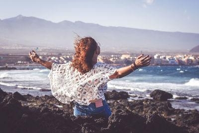 Rear view of woman standing on beach