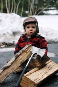 Close-up of cute toddler behind firewood