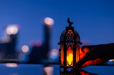 Lantern that have moon symbol on top holding by hand for  holy month of ramadan kareem.