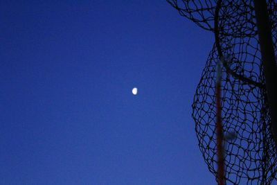 Low angle view of moon against blue sky