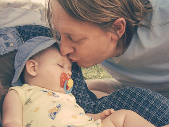 Close-up of father kissing cute son in baby stroller